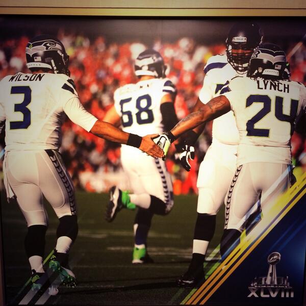Russell Wilson high-fives Marshawn Lynch on the field. Photo via @DangeRussWilson.