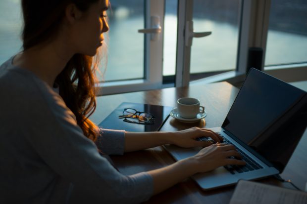woman writing a blog on a laptop 